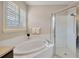 Spa-like bathroom with soaking tub, walk-in shower, and window at 2104 Park Crescent Drive, Land O Lakes, FL 34639