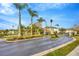 Gated community entrance with palm trees and a pond at 2104 Park Crescent Drive, Land O Lakes, FL 34639