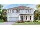 Two-story house with gray siding, a two-car garage, and landscaping at 2577 Chapel Oak Bnd, Wesley Chapel, FL 33543