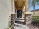 Elegant front entry with stone columns and a dark brown door at 2670 Tarragona Way, Wesley Chapel, FL 33543