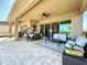 Relaxing covered patio featuring comfortable seating and a ceiling fan at 2670 Tarragona Way, Wesley Chapel, FL 33543