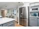 Modern kitchen with stainless steel refrigerator and light gray cabinets at 3200 Gulf Blvd # 204, St Pete Beach, FL 33706