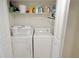 Laundry closet with washer, dryer, and storage shelves at 3200 Gulf Blvd # 204, St Pete Beach, FL 33706