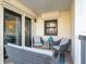 Relaxing patio with wicker furniture and sliding glass doors leading to the interior at 3200 Gulf Blvd # 204, St Pete Beach, FL 33706