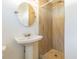 Modern bathroom with pedestal sink and beige tile shower at 3709 W Oklahoma Ave, Tampa, FL 33611