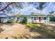 Ranch home with red door and mature landscaping at 3709 W Oklahoma Ave, Tampa, FL 33611