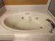 Oval jacuzzi bathtub with jets and tiled surround at 3830 Stornoway Dr, Land O Lakes, FL 34638