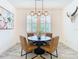 Modern dining area with a round table and four brown leather chairs at 4456 Tubular Run, Land O Lakes, FL 34638