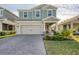 Two-story house with light teal siding, gray garage door, and landscaped front yard at 4456 Tubular Run, Land O Lakes, FL 34638