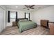 Bright bedroom with wood-look floors, large bed, and dresser at 4520 N Matanzas Ave, Tampa, FL 33614