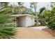 White mid-century modern home with gravel driveway and tropical landscaping at 5027 Sunrise S Dr, St Petersburg, FL 33705