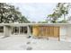 Mid-century modern home with a yellow door and geometric patterned walkway at 5027 Sunrise S Dr, St Petersburg, FL 33705