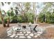 Charming fire pit area with stone patio and comfortable seating in a garden setting at 5027 Sunrise S Dr, St Petersburg, FL 33705