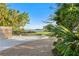 Landscaped front yard with a gravel driveway and tranquil waterfront view at 5027 Sunrise S Dr, St Petersburg, FL 33705