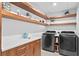 Clean laundry room with white walls, wood shelving, and modern appliances at 5027 Sunrise S Dr, St Petersburg, FL 33705