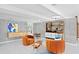 Mid-century modern living room with orange armchairs and a built-in cabinet at 5027 Sunrise S Dr, St Petersburg, FL 33705