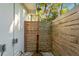 Private outdoor shower with wood privacy walls and pebble flooring at 5027 Sunrise S Dr, St Petersburg, FL 33705