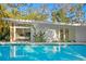 Refreshing swimming pool view adjacent to a renovated home with sliding glass doors at 5027 Sunrise S Dr, St Petersburg, FL 33705