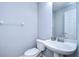 Simple, clean bathroom with white pedestal sink and toilet at 5103 Ashcrest Ct, Tampa, FL 33647