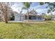 Back exterior view of the house showcasing the screened porch and grassy yard at 5200 Lagos Ct, New Port Richey, FL 34655