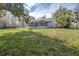 Back exterior view, showcasing the house and spacious grassy backyard at 5200 Lagos Ct, New Port Richey, FL 34655