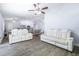 Open living room with white sofas and view into the kitchen at 5200 Lagos Ct, New Port Richey, FL 34655