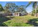 Large backyard with grassy area, wooden fence, and patio at 6706 S Kissimmee St, Tampa, FL 33616