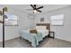 Spacious bedroom with a queen bed, ceiling fan, and large windows at 6706 S Kissimmee St, Tampa, FL 33616