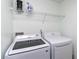 Functional laundry room with washer, dryer, and overhead shelving at 6706 S Kissimmee St, Tampa, FL 33616