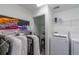 Laundry room with washer, dryer, shelving, and extra storage at 6706 S Kissimmee St, Tampa, FL 33616