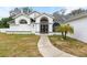 White house with gray roof and arched entryway at 8535 Delaware Dr, Weeki Wachee, FL 34607