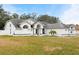 White house with gray roof, arched entryway, and landscaped lawn at 8535 Delaware Dr, Weeki Wachee, FL 34607