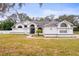 White house with gray roof, arched entryway, and landscaped lawn at 8535 Delaware Dr, Weeki Wachee, FL 34607