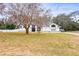 Large white house with a spacious lawn and mature trees at 8535 Delaware Dr, Weeki Wachee, FL 34607