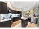 Modern kitchen with dark cabinetry, quartz counters, and stainless steel appliances at 8535 Delaware Dr, Weeki Wachee, FL 34607