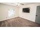 Spacious bedroom with wall-mounted TV, ceiling fan, and neutral carpeting at 8615 Greenfield Ln, Zephyrhills, FL 33541