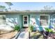 Charming light blue home with a walkway and potted plants at 8615 Greenfield Ln, Zephyrhills, FL 33541