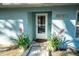 Charming light blue home with a walkway and potted plants at 8615 Greenfield Ln, Zephyrhills, FL 33541