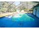 Screened pool area with a partially shaded deck at 8615 Greenfield Ln, Zephyrhills, FL 33541