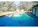 Screened pool area with a partially shaded deck at 8615 Greenfield Ln, Zephyrhills, FL 33541