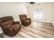 Relaxing sitting area with two brown recliners and wood-look floors at 8615 Greenfield Ln, Zephyrhills, FL 33541