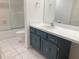 Bright bathroom with white tiled floors and a dark vanity at 102 Mariner Dr, Tarpon Springs, FL 34689