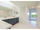 Bathroom with dual sinks, dark vanity, and tile floor at 102 Mariner Dr, Tarpon Springs, FL 34689