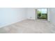 Bedroom with neutral carpeting and sliding glass doors at 102 Mariner Dr, Tarpon Springs, FL 34689