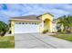 Front view of a yellow house with a white garage door at 11511 Lounds Ct, New Port Richey, FL 34654