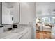 Bathroom with white marble countertop, sleek black faucet, and an open view into the bright, modern living area at 11624 Monette Rd, Riverview, FL 33569