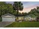 Charming white house with a landscaped lawn and palm trees at 11624 Monette Rd, Riverview, FL 33569