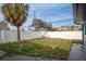 Small backyard with unkempt grass and a white fence at 117 73Rd Ave, St Pete Beach, FL 33706