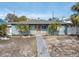 Single-story home with light blue exterior, palm trees, and walkway at 117 73Rd Ave, St Pete Beach, FL 33706