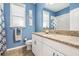 Clean bathroom with blue walls, granite countertop, and white cabinets at 12292 Lyon Pine Ln, Odessa, FL 33556